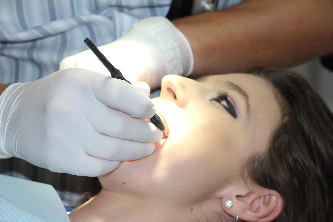 A dentist checking a woman's teeth